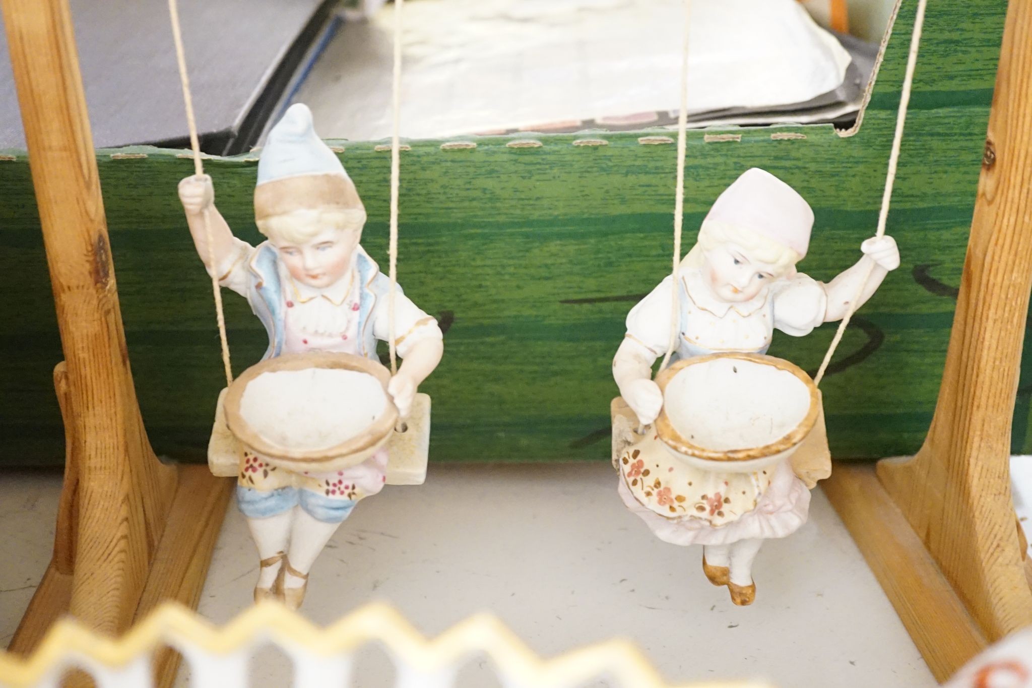 A pair of bisque swinging figures, Royal Worcester cabinet cup and saucer and five other items
